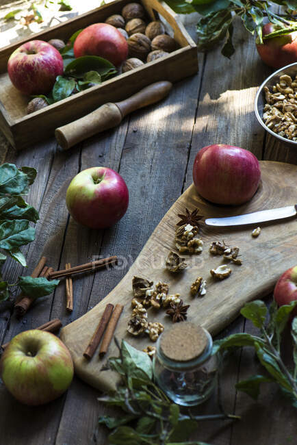 Розташування яблук, волоських горіхів та спецій на дерев'яному столі — стокове фото