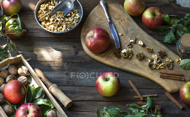 Apples, walnuts and spice arrangement on a wooden table — Stock Photo