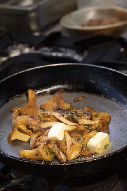 Mushrooms being cooked in butter and thyme in a frying pan — Stock Photo