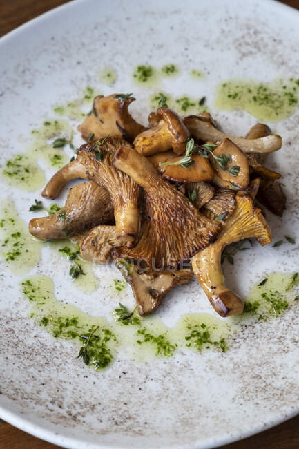 Крупный план жареных диких грибов с маслом и тимьяном — стоковое фото