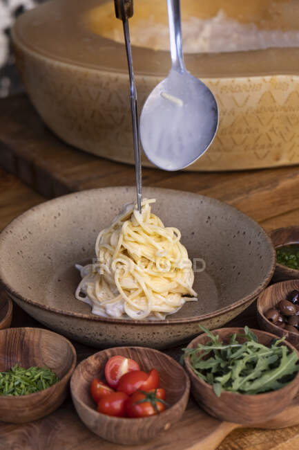 Espaguete com molho de queijo grana padano sendo servido — Fotografia de Stock