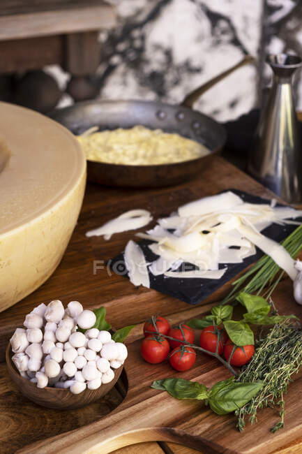 Close-up of ingredients next to a hollow grana padano wheel — Stock Photo