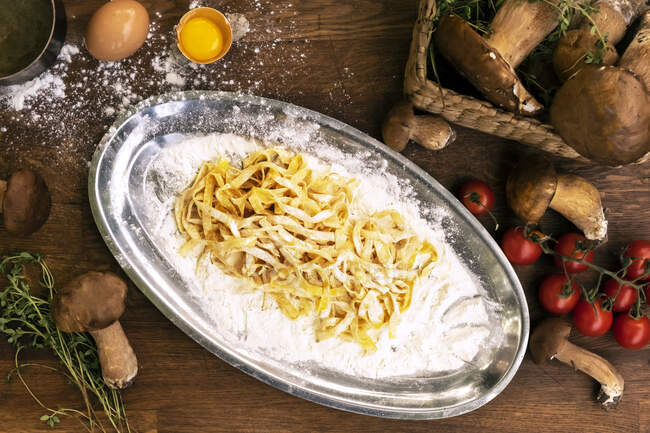Freshly made tagliatelle pasta with mushroom, tomato and thyme — Stock Photo