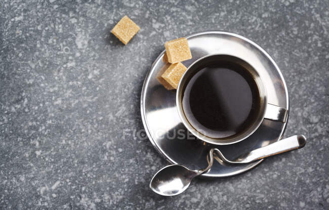 Cup of black coffee with sugar cubes — Stock Photo