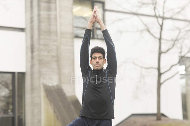 Portrait of a man standing outside doing yoga, Germany — Stock Photo