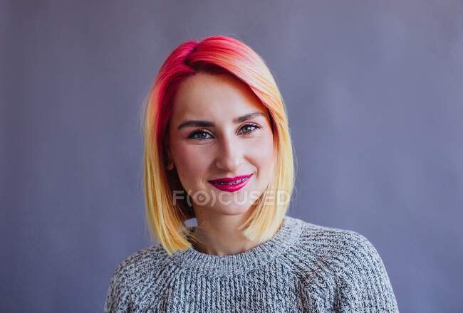 Portrait of a cool girl with dyed hair sitting on a chair — Stock Photo