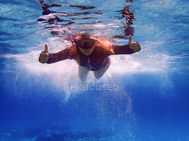 Жінка плаває в морі, показуючи пальцями вгору знак, Греція. — стокове фото