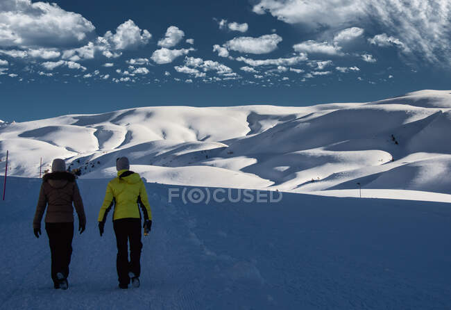 Dos mujeres caminando en un paisaje alpino, Suiza - foto de stock