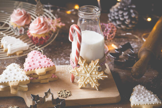 Bolinhos de Natal, cupcakes e uma garrafa de leite — Fotografia de Stock