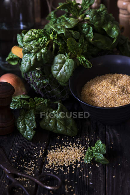 Spinach, onion, and bulgur wheat on a wooden table — Stock Photo