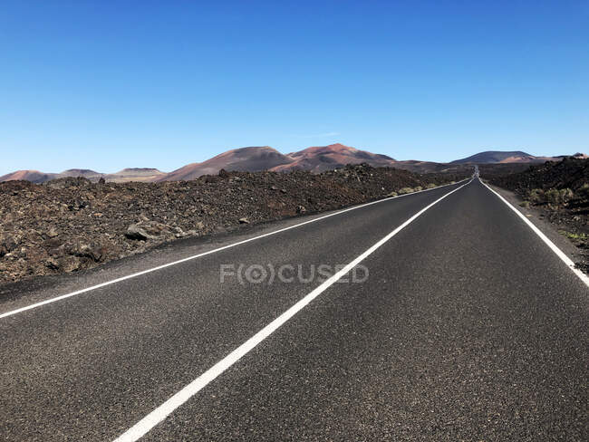Geradlinige Straße durch vulkanisches Gelände, Timanfaya, Lanzarote, Kanarische Inseln, Spanien — Stockfoto
