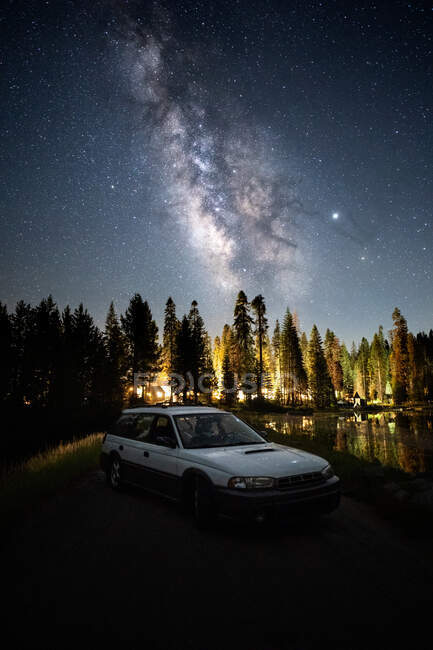 Car parked on a Road at Night by Illuminated camp site in the Forest, Sequoia National Park, California, USA — Stock Photo