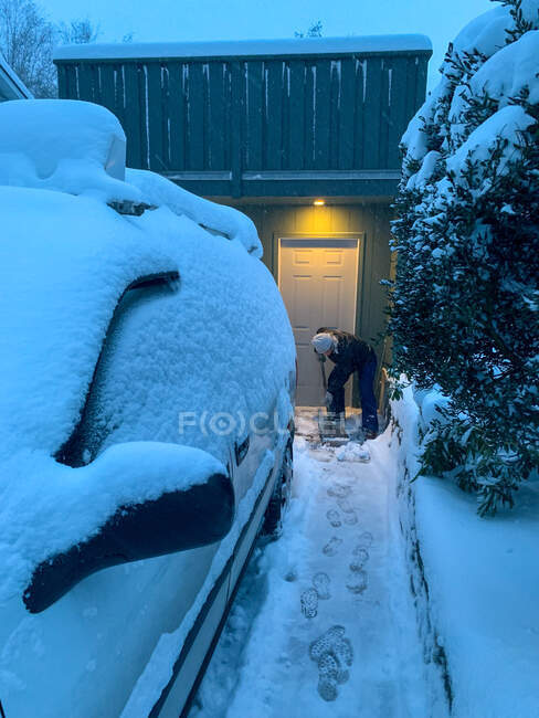 Donna che libera la neve dal suo vialetto, Canada — Foto stock