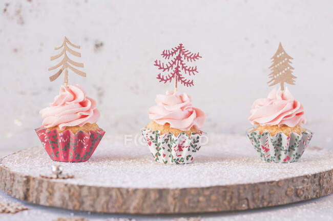 Кексы с масляными глазурью украшены елками — стоковое фото