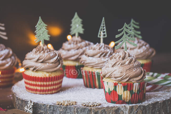 Cupcakes con glaseado de crema de chocolate decorado con árboles de Navidad - foto de stock