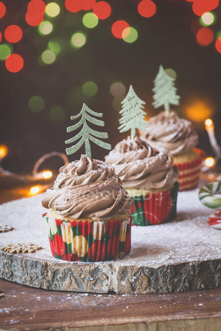 Cupcakes com cobertura de creme de chocolate decorado com árvores de Natal — Fotografia de Stock