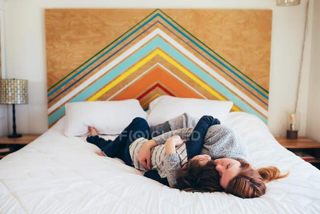 Мати і син лежать і обіймаються разом на ліжку — стокове фото