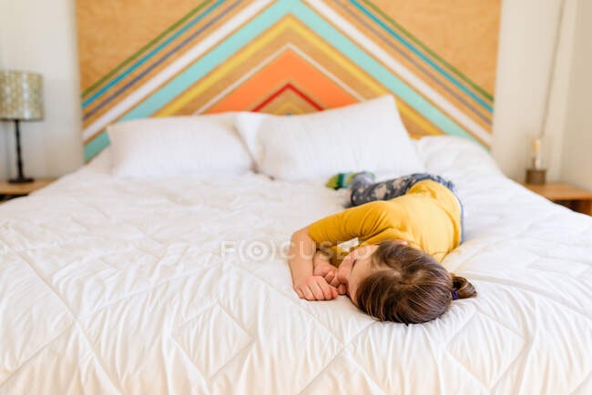 Девочка лежит на кровати и спит. — стоковое фото