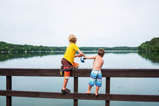 Due ragazzi in piedi su un molo di pesca, USA — Foto stock