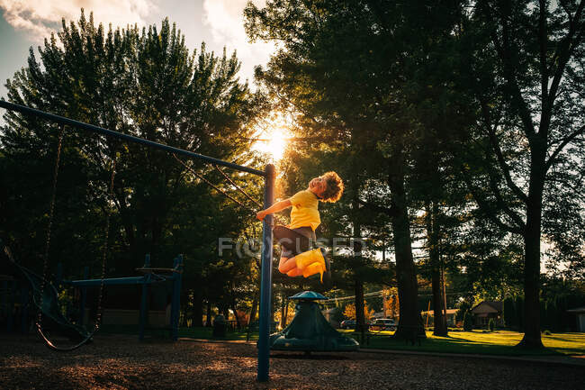 Chico balanceándose en un columpio en un parque, EE.UU. - foto de stock