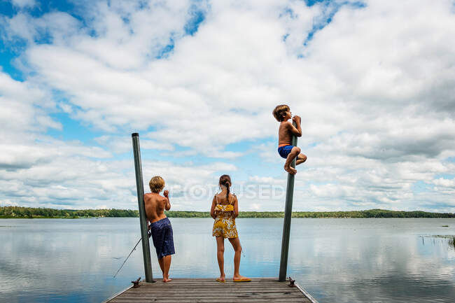 Tre bambini in piedi su un molo di pesca e scherzare, Stati Uniti — Foto stock