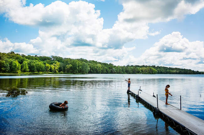 Tres niños en el lago de pesca y divertirse, EE.UU. - foto de stock