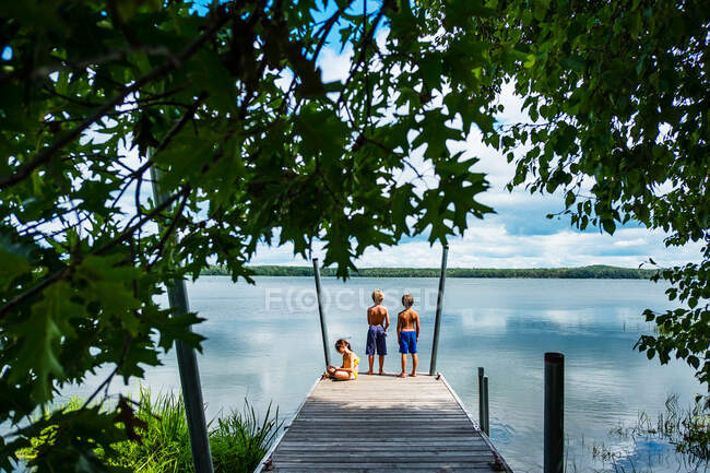 Drei Kinder auf einem Dock beim Angeln, USA — Stockfoto