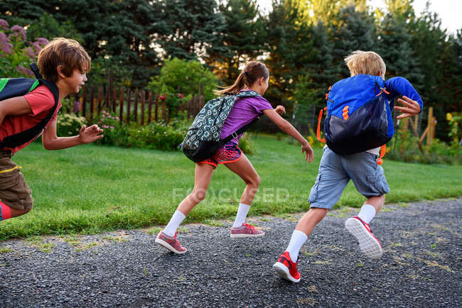 Tres niños corriendo por un sendero, EE.UU. - foto de stock