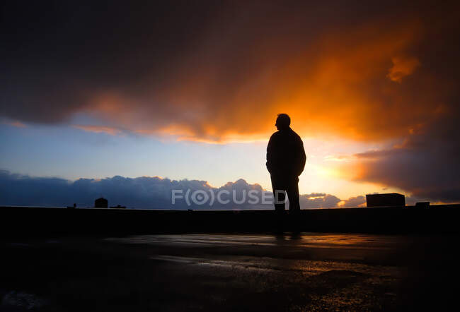 Silhueta de um homem em pé em um telhado, Canadá — Fotografia de Stock