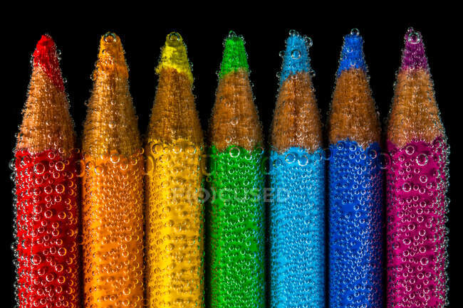 Multi coloured pencils submerged in water — Stock Photo