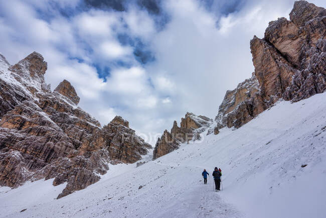 Hikers below Tofana de Rozes, Parco Naturale delle Dolomiti d'Ampezzo near Cortina d'Ampezzo, South Tyrol, Italy — Stock Photo