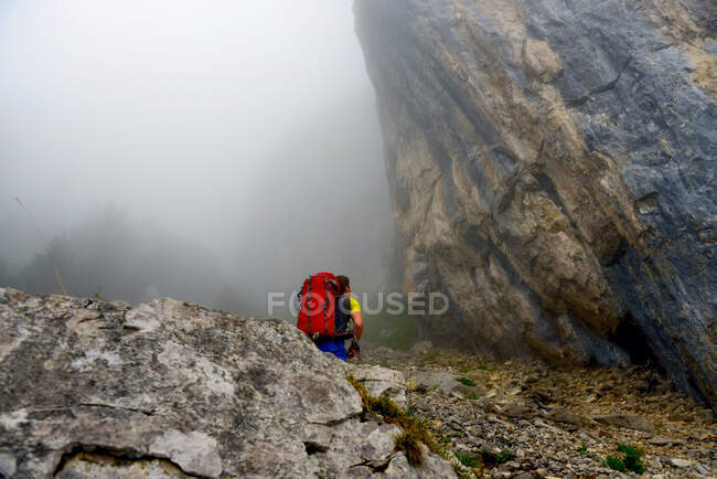 Hombre escalando en la niebla, Ebenalp, Suiza - foto de stock
