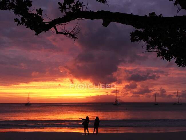 Silhouette von zwei Personen am Strand bei Sonnenuntergang, Seychellen — Stockfoto
