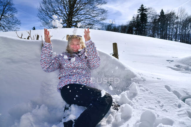 Щаслива жінка кидає сніг в повітря, Хасліберг, Інтерлакен-Оберхаслі, Швейцарія — стокове фото