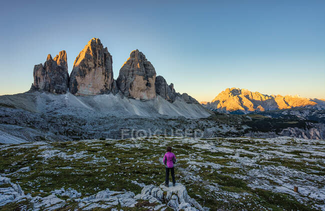 Mujer mirando Sunrise, Tre Cime di Lavaredo, Dolomitas, Tirol del Sur, Italia - foto de stock