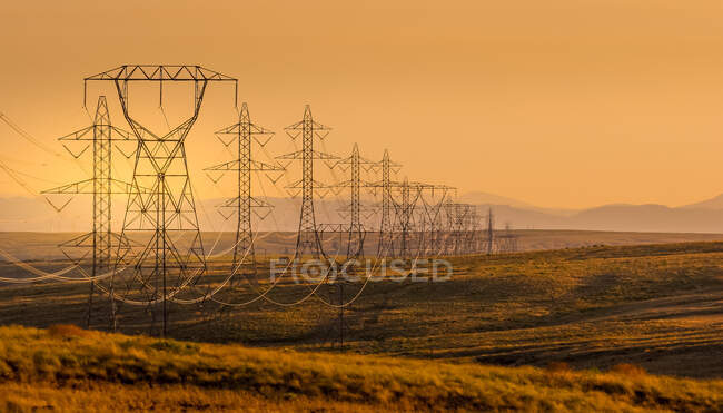 Linee elettriche attraverso un paesaggio rurale al tramonto, USA — Foto stock