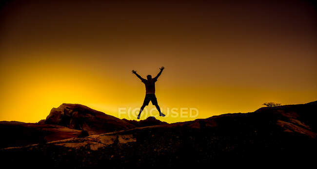 Silhouette of a man jumping in the air in the desert, Valley of Fire State Park, Nevada, USA — Stock Photo