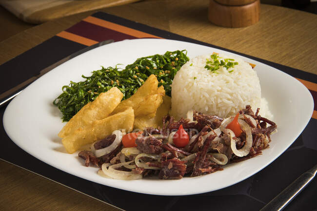 Jerk beef with rice, kale and fried manioc — Stock Photo