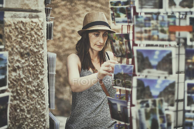 Женщина, выбирающая открытку, Мальорка, Балеарские острова, Испания — стоковое фото
