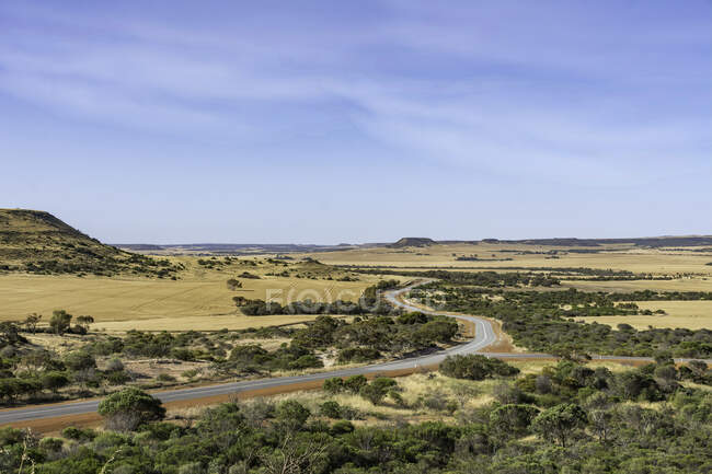 Camino sinuoso a través del paisaje rural, región del Medio Oeste, Australia Occidental, Australia - foto de stock