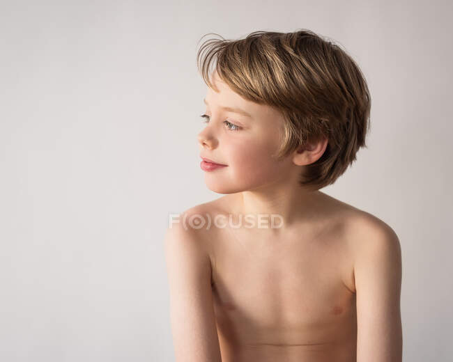 Retrato de un niño sonriente mirando hacia los lados - foto de stock