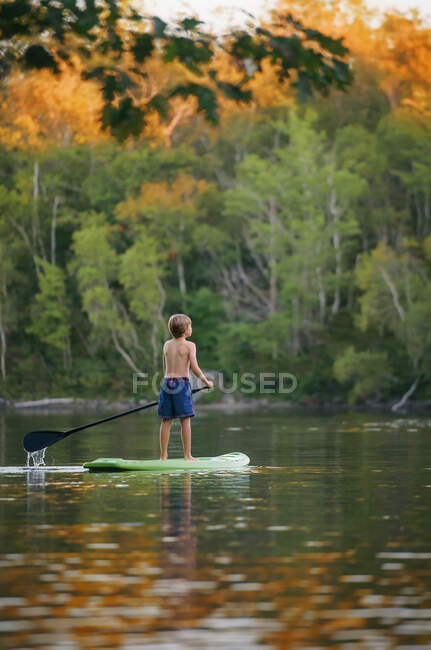 Boy paddleboarding on a lake, Bedford, Halifax, Nueva Escocia, Canadá - foto de stock