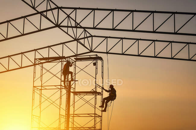 Silhouette of two construction workers on a construction site, Thailand — Stock Photo