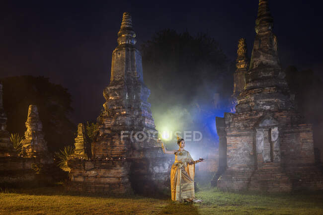 Donna in costume tradizionale in piedi di fronte a un tempio, Bangkok, Thailandia — Foto stock