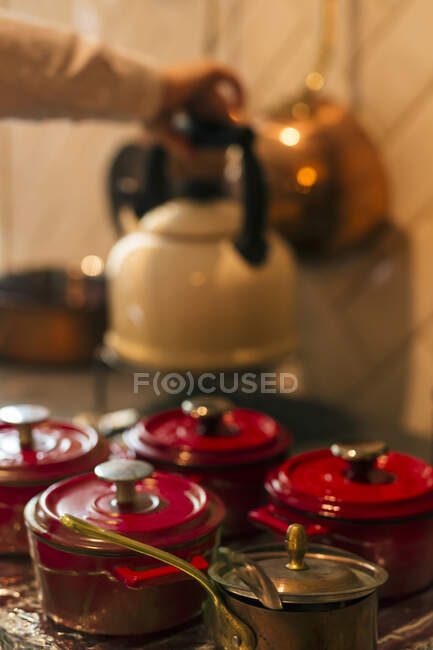 Рука людини кладе чайник на кухонну стільницю маленькими запіканками — стокове фото