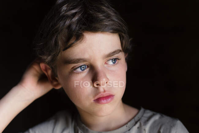 Porträt eines nachdenklichen Jungen, der sich auf seinen Ellbogen stützt — Stockfoto