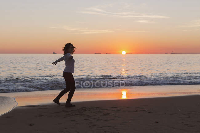 Frau tanzt am Strand bei Sonnenuntergang, Spanien — Stockfoto