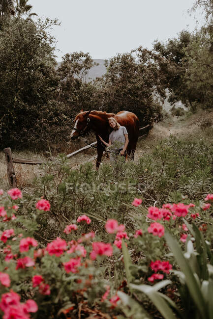 Menina caminhando através da paisagem rural com seu cavalo, Califórnia, EUA — Fotografia de Stock
