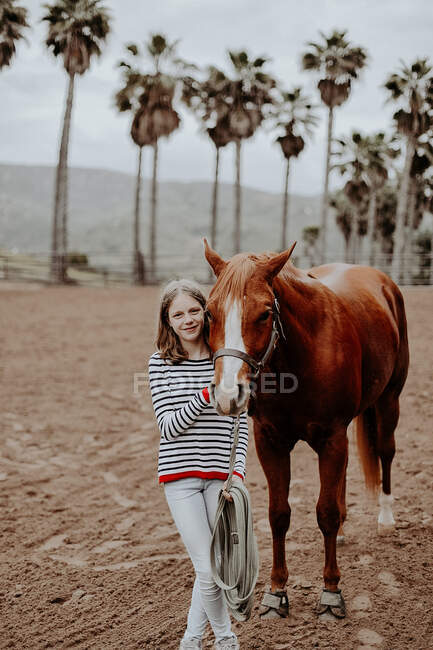 Portrait of a smiling girl standing next to her horse, California, USA — Stock Photo