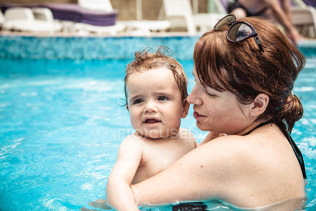Felice madre nuotare in una piscina con il suo bambino figlio, Bulgaria — Foto stock